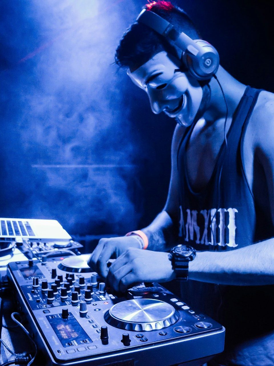 man in black tank top playing dj mixer